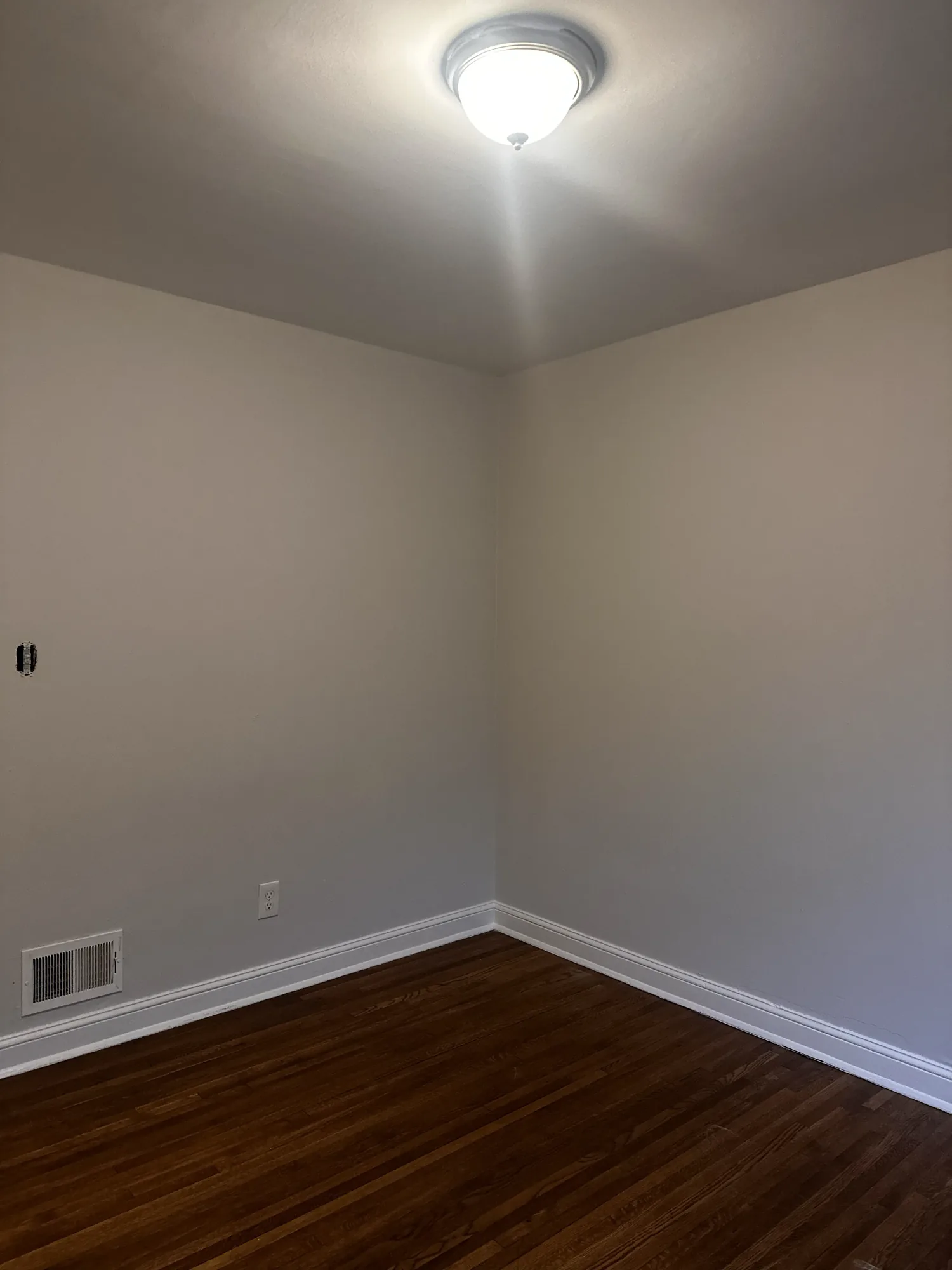 Freshly painted bedroom with pale grey walls and white trim in a South Minneapolis duplex