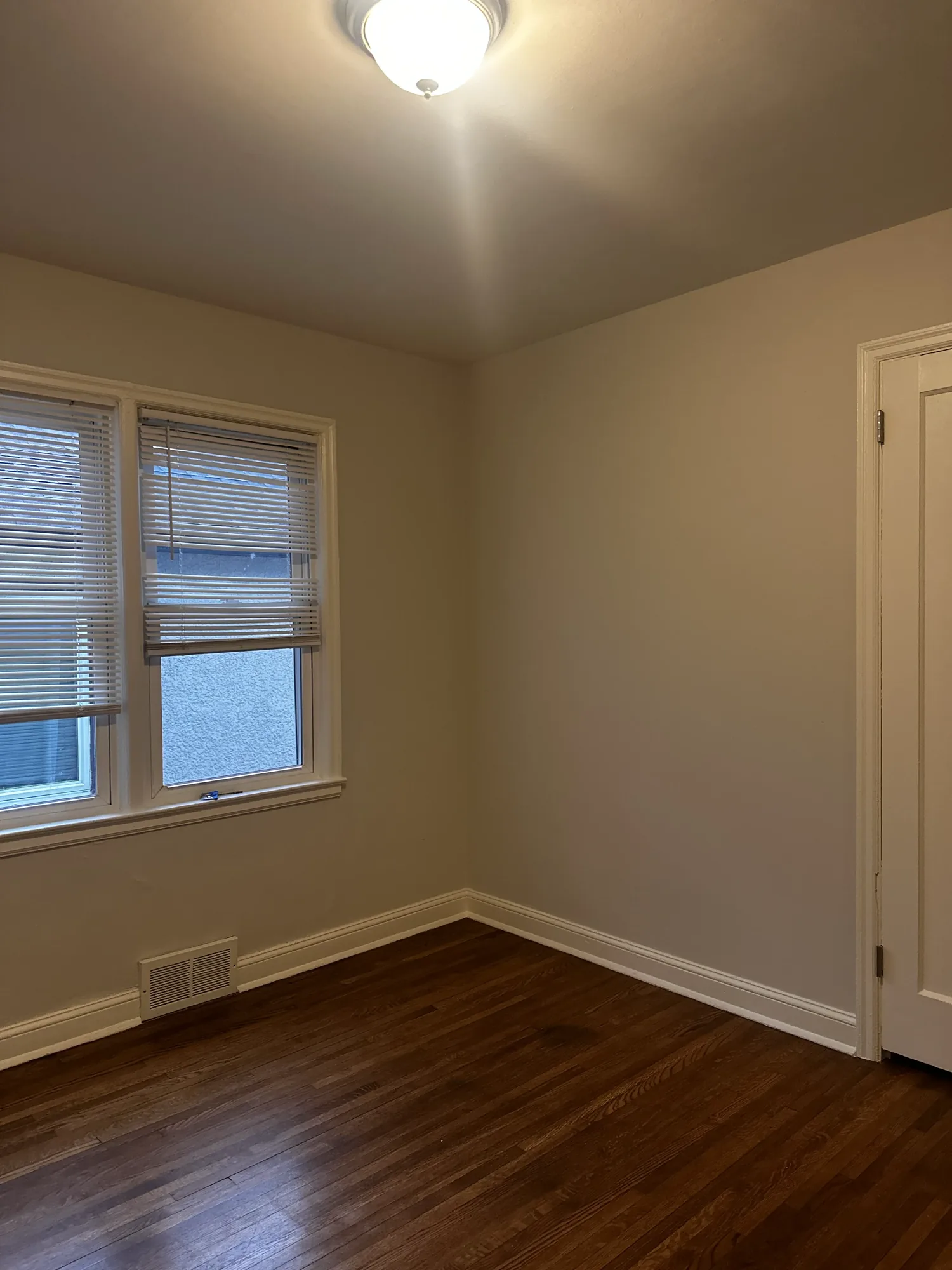 Another view of the repainted bedroom showing clean cut-in lines at the window trim