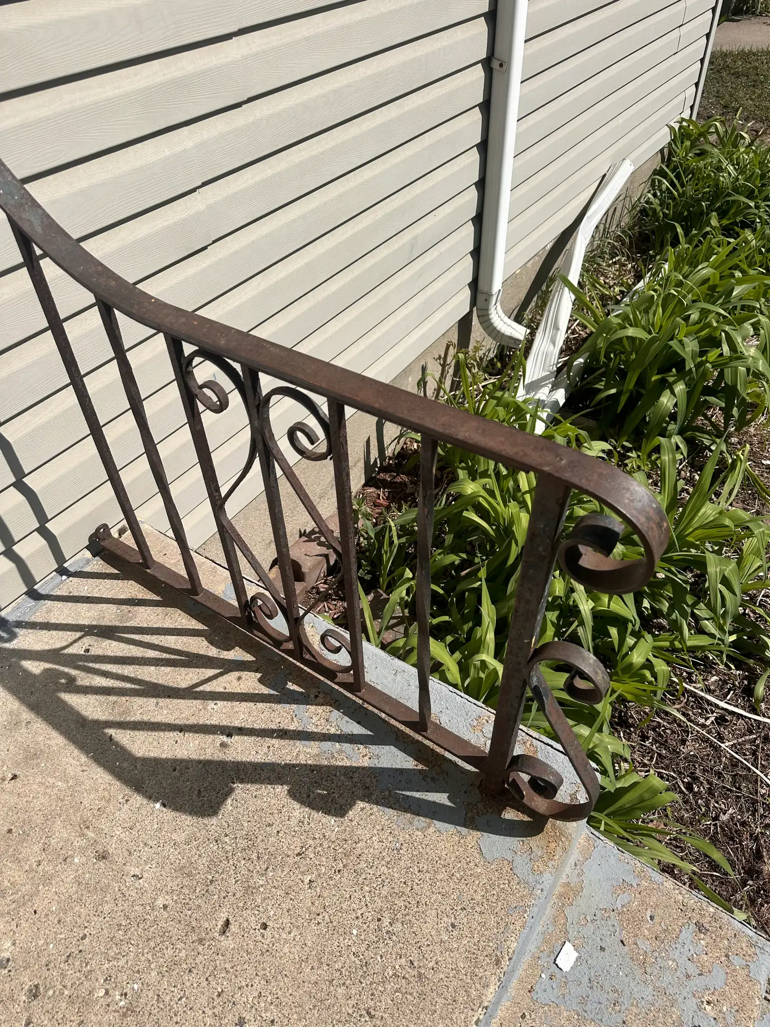 Badly rusted wrought iron porch railing before restoration at a South Minneapolis duplex