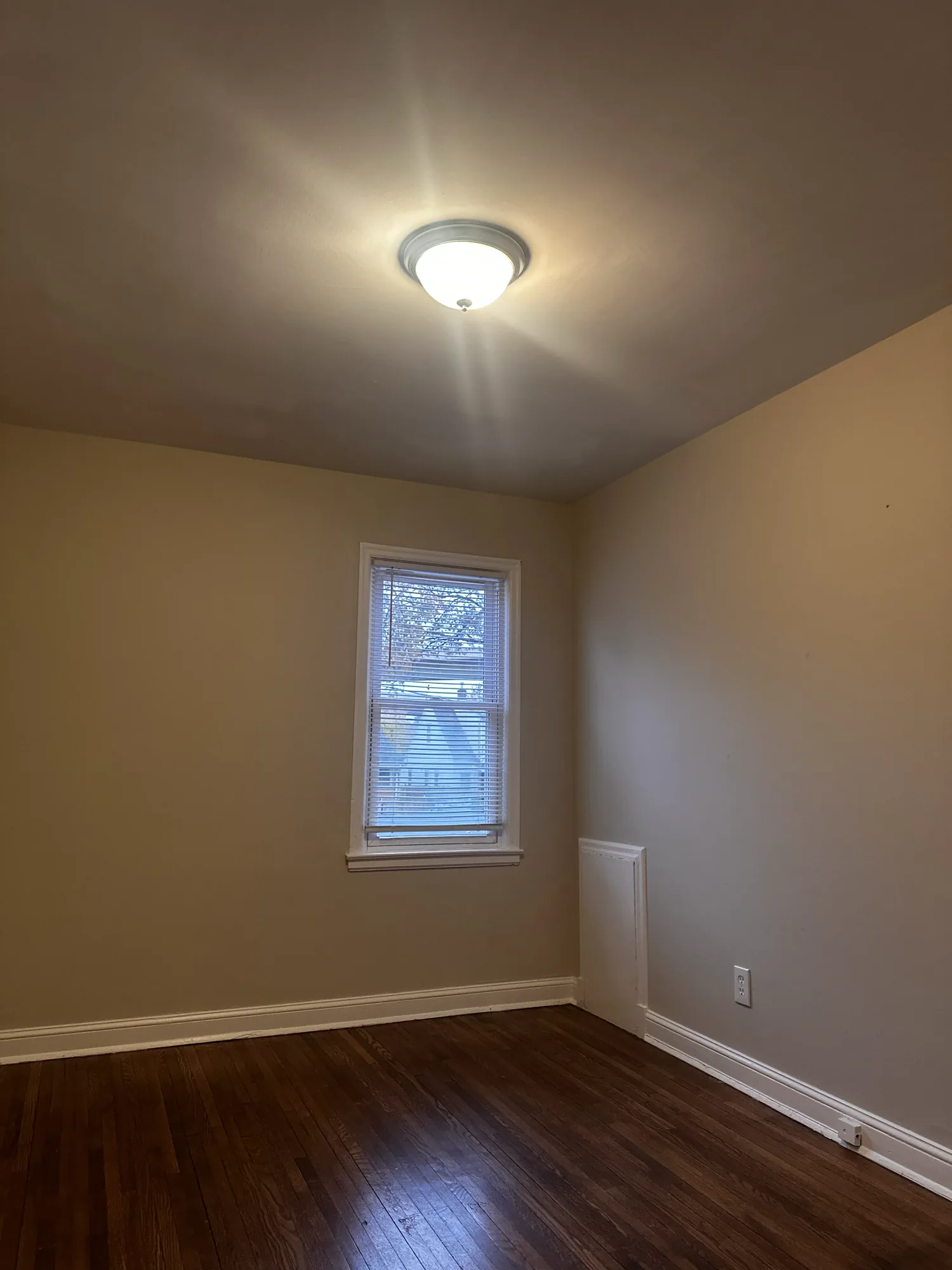 Second bedroom after painting, in a warm neutral with white ceiling and trim