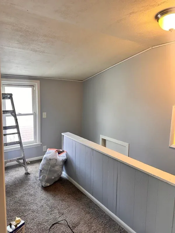 The same stairwell repainted in a light grey that brightens the landing