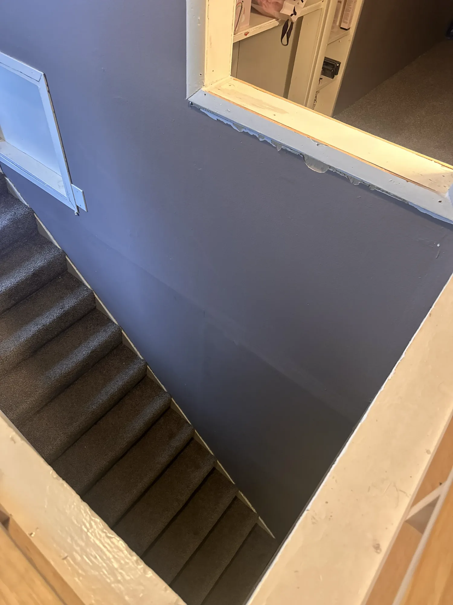 Stairwell painted a dark blue-purple before repainting in a South Minneapolis duplex