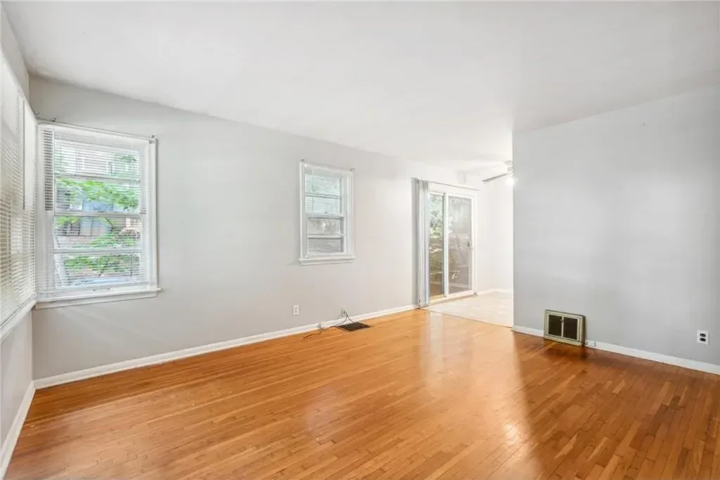 Second bedroom after painting, empty and ready for new tenants, with hardwood floors and bright walls