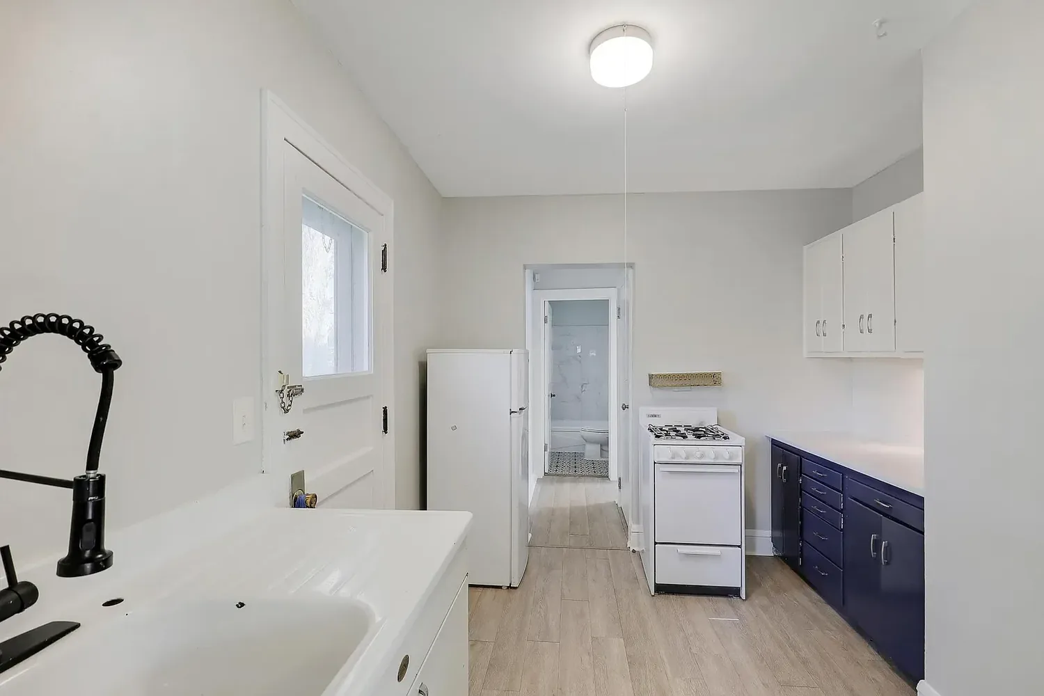 Kitchen after painting, with grey walls and white ceiling alongside updated cabinetry
