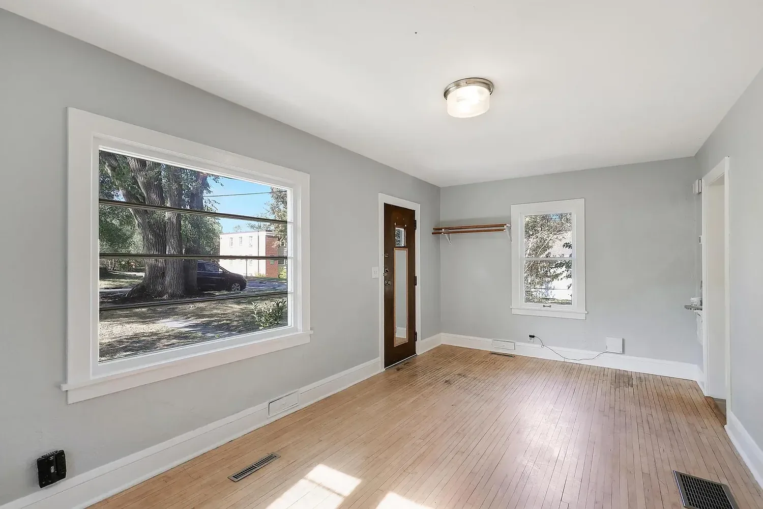 Repainted living room in warm grey with white trim and refinished hardwood floors, St. Louis Park